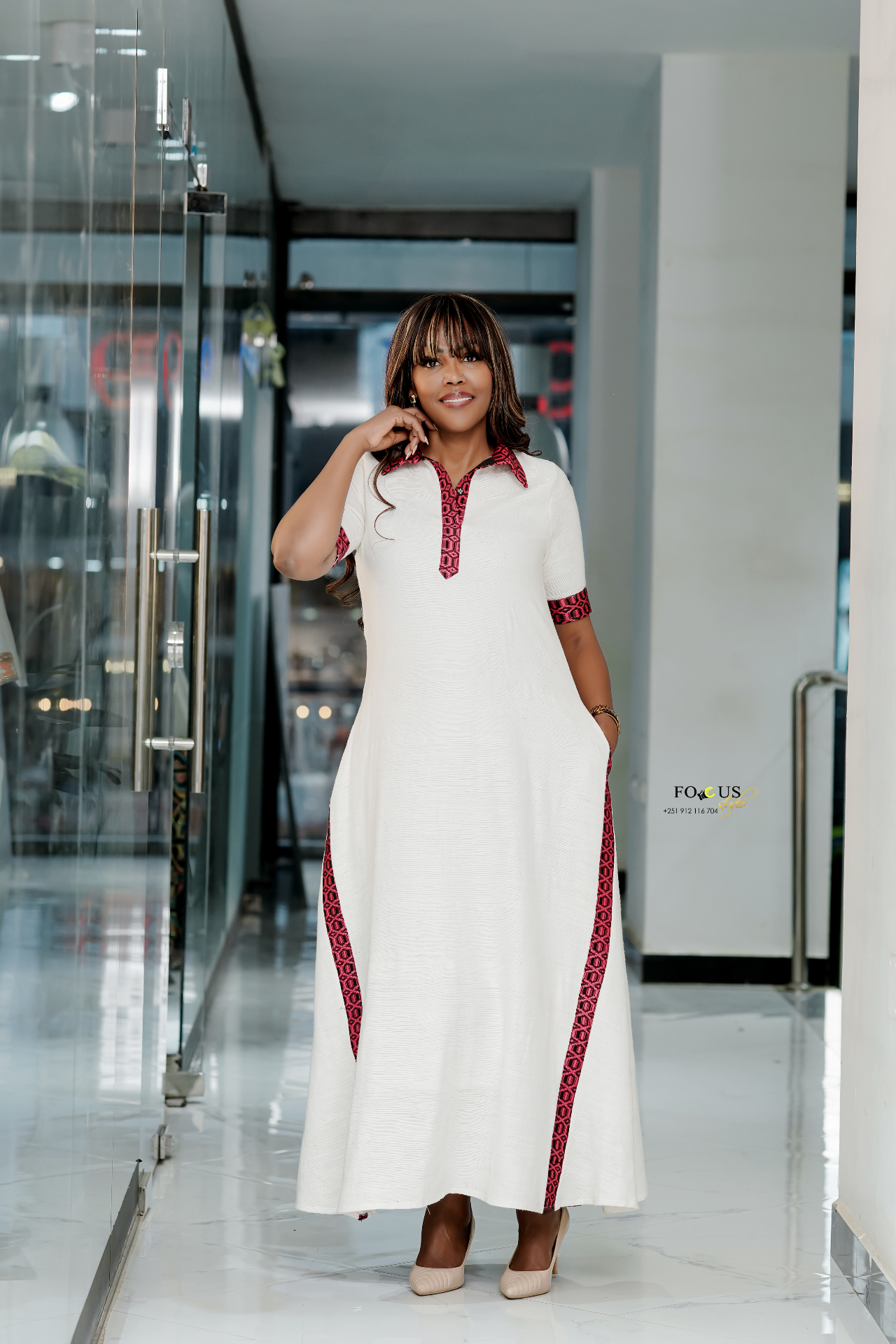 Sara Mohamed in a white dress with red Ethiopian patterned trim